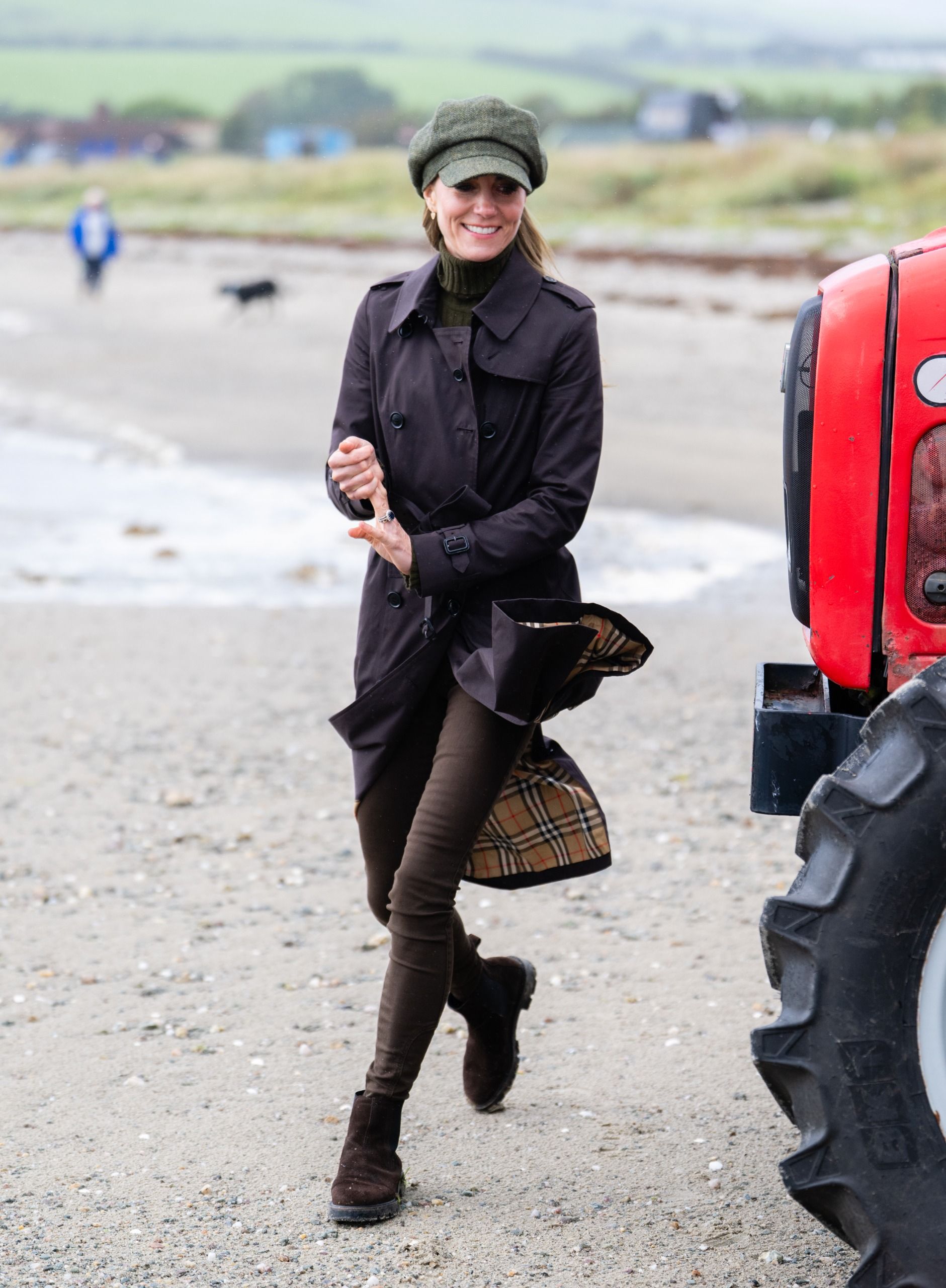 Kate Middleton wears brown skinny jeans and a green turtleneck sweater with a Burberry trench coat