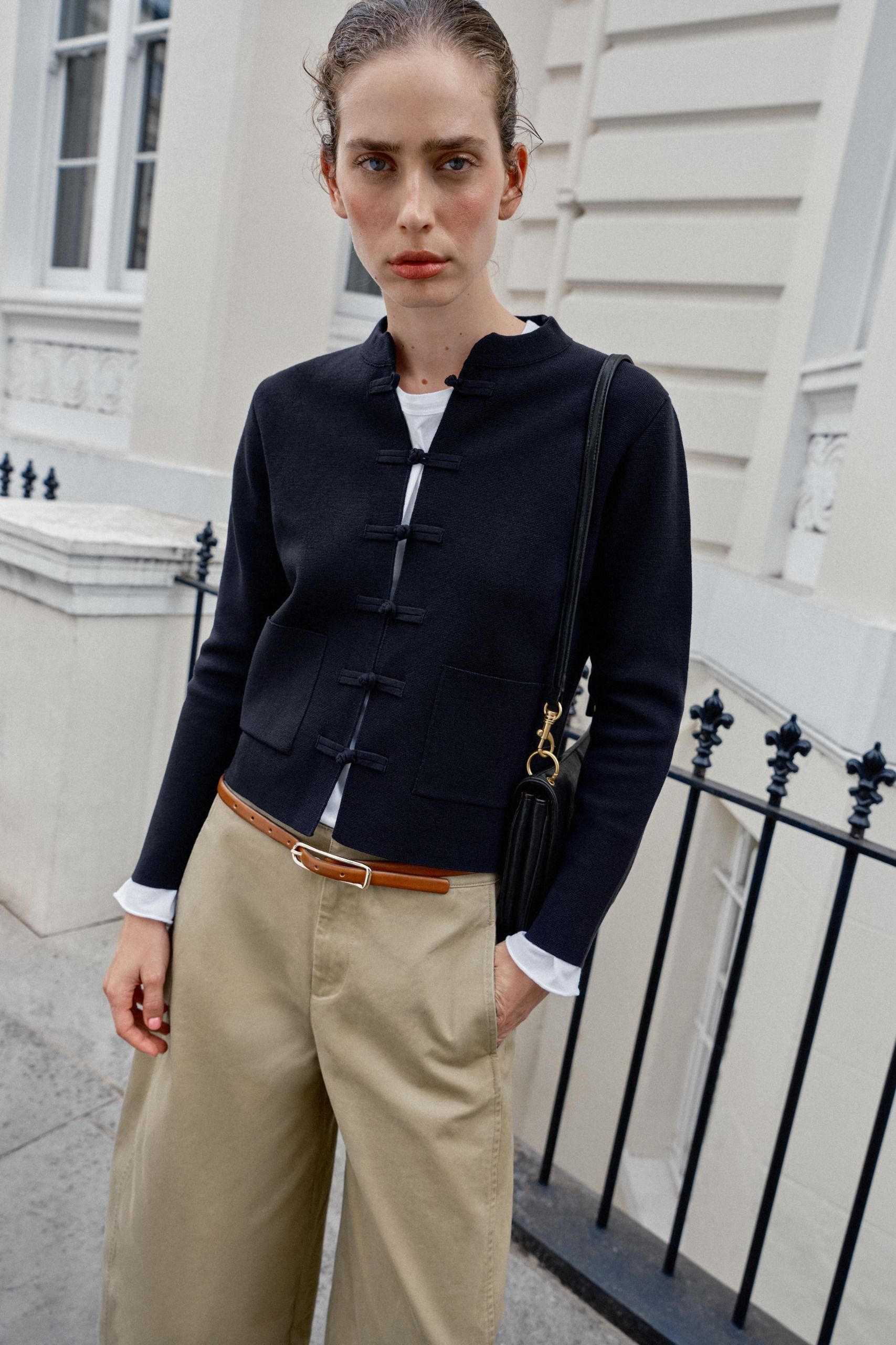 model wears Zara's frog-fastening cardigan