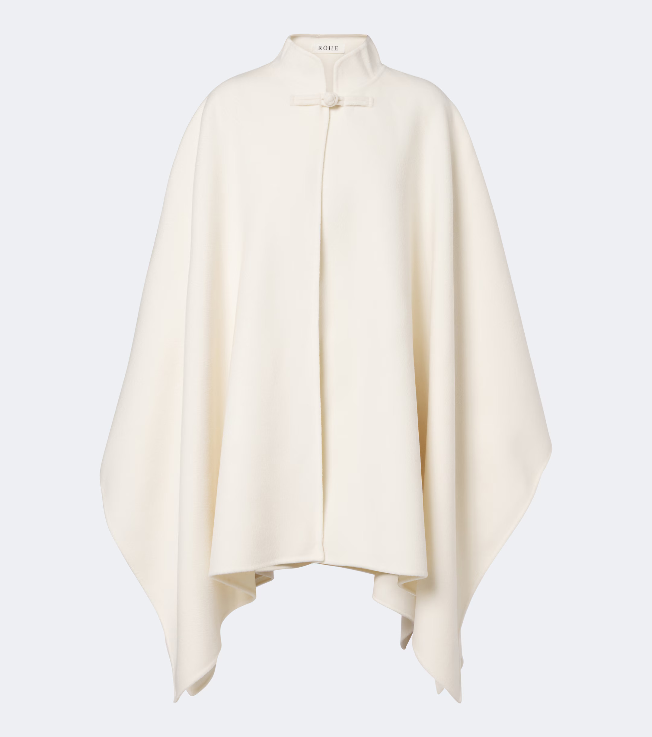 An image of a cream-coloured cape jacket with a frog-fastening closure at the neck