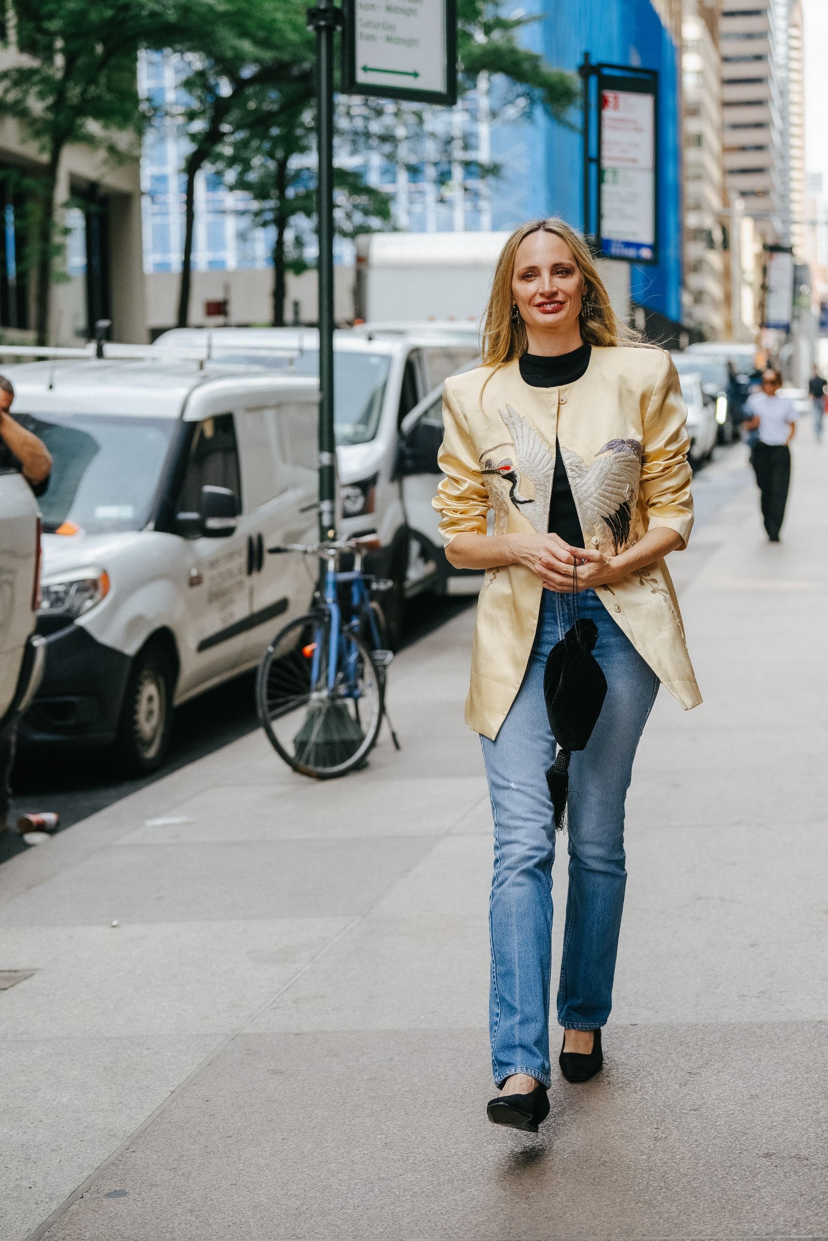 Lauren Santo Domingo wearing a yellow satin Conner Ives evening jacket with jeans during NYFW