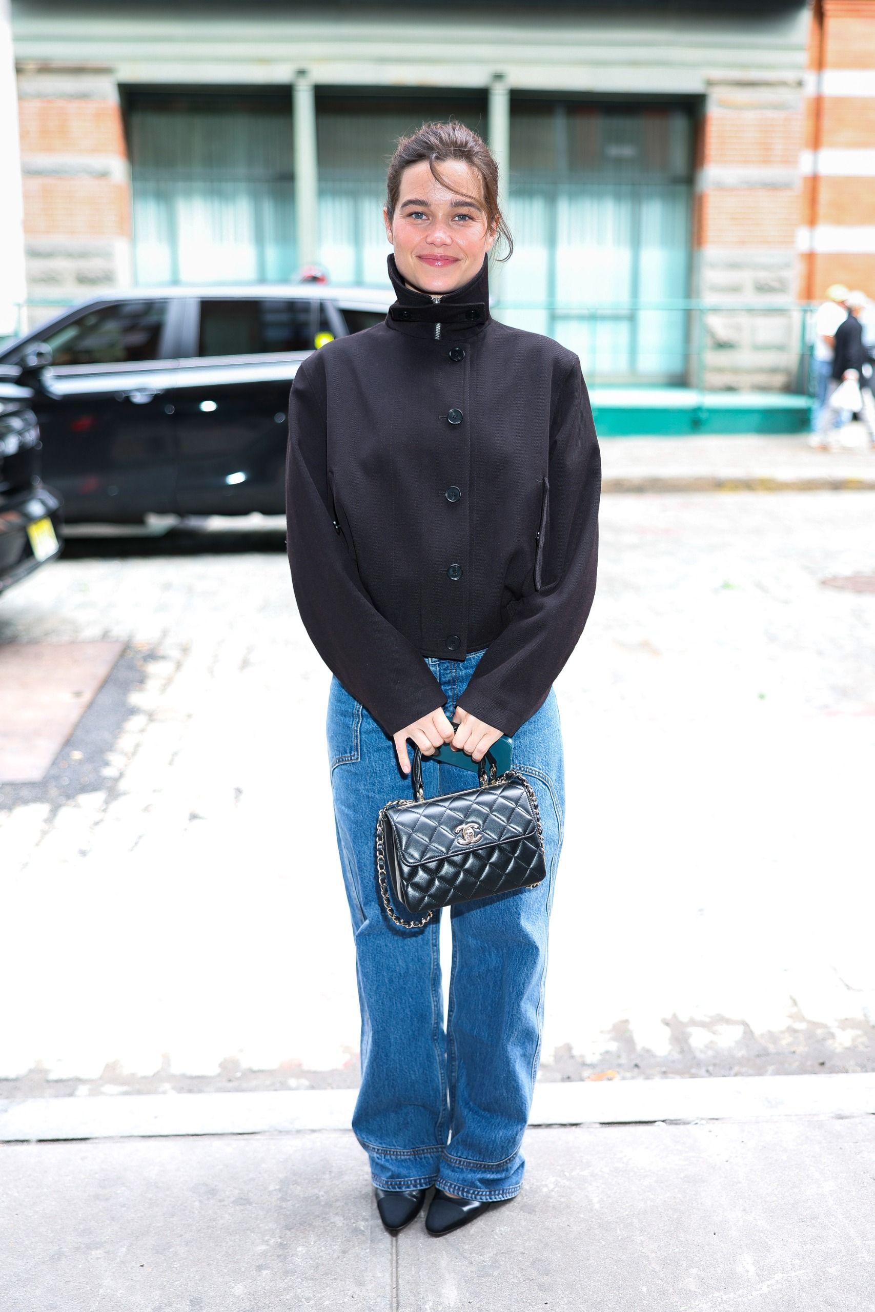 Sarah Catherine wears puddle jeans with pointed-toe heels and a black high-neck jacket at a Chanel event in New York.