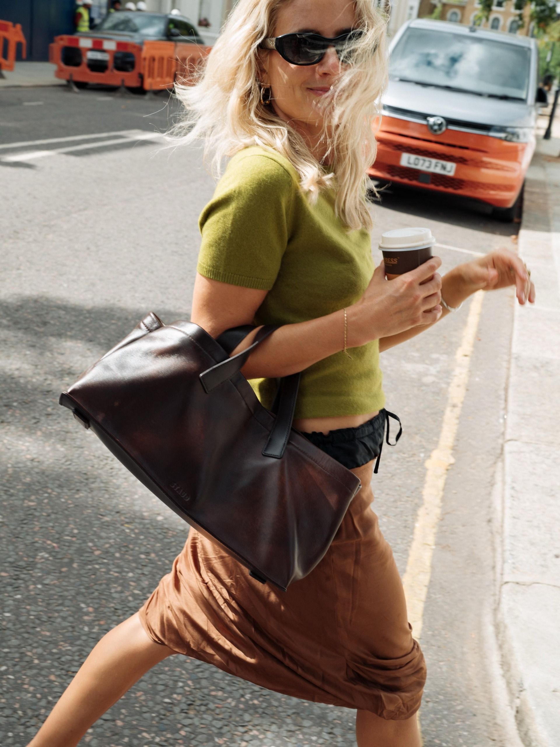 colourful capsule wardrobe autumn 2026: Lucy williams. She wears a grass green top with a brown skirt, and black handbag. This image was recently taken from her Instagram.