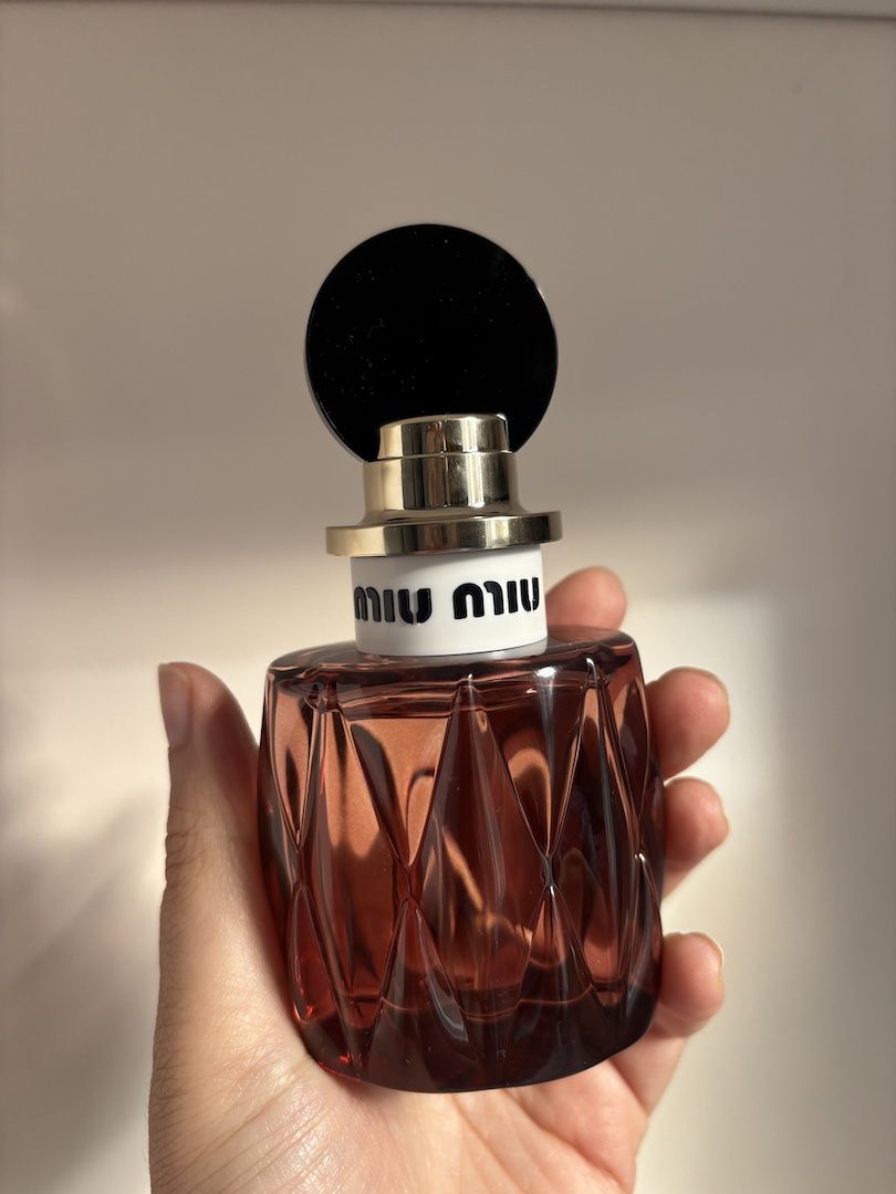 Mica Ricketts holding bottle of Miu Miu Miutine Intense