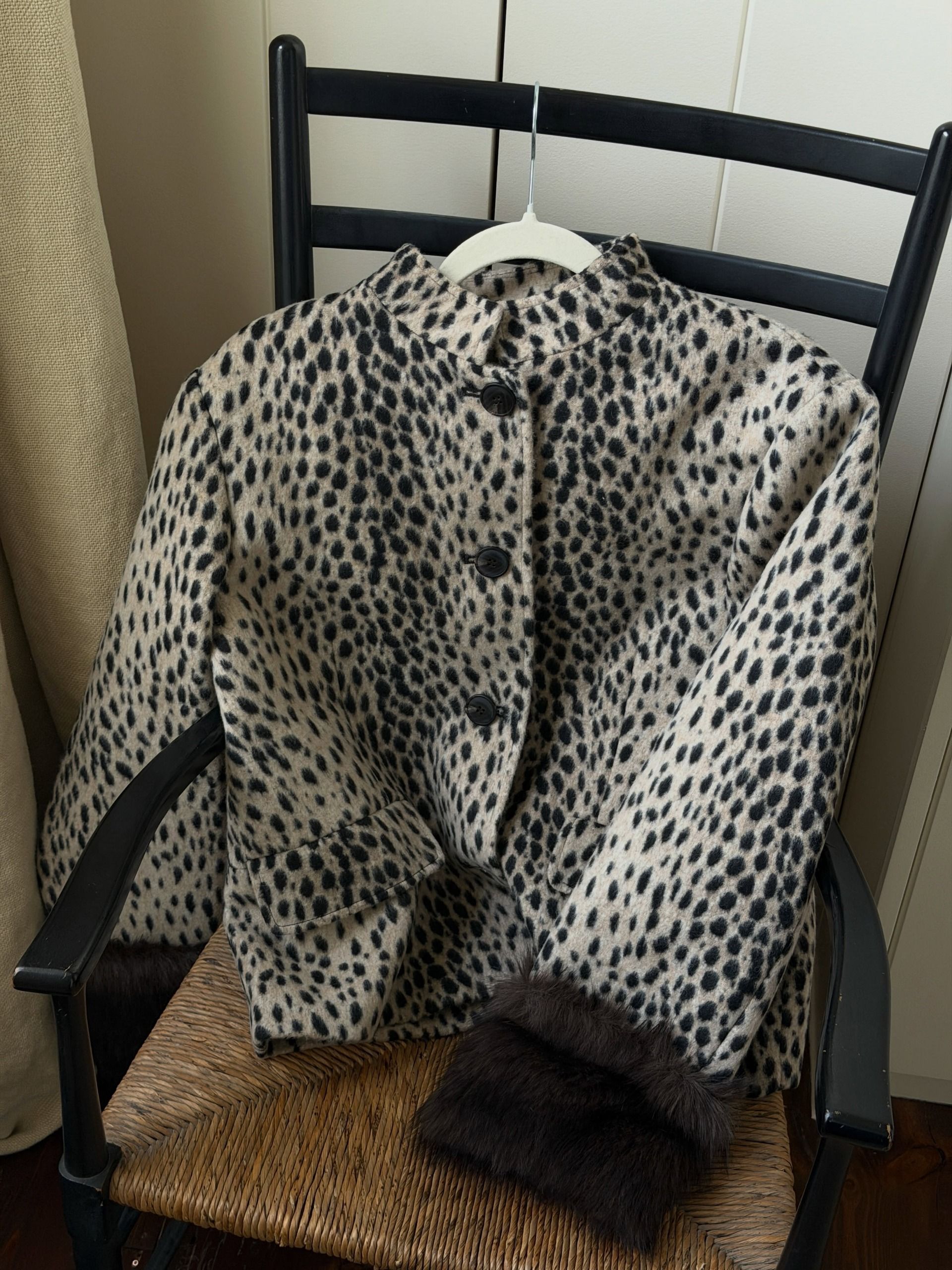 @india.cardona showcases M&S's sold out leopard print, faux-fur jacket on a rattan chair