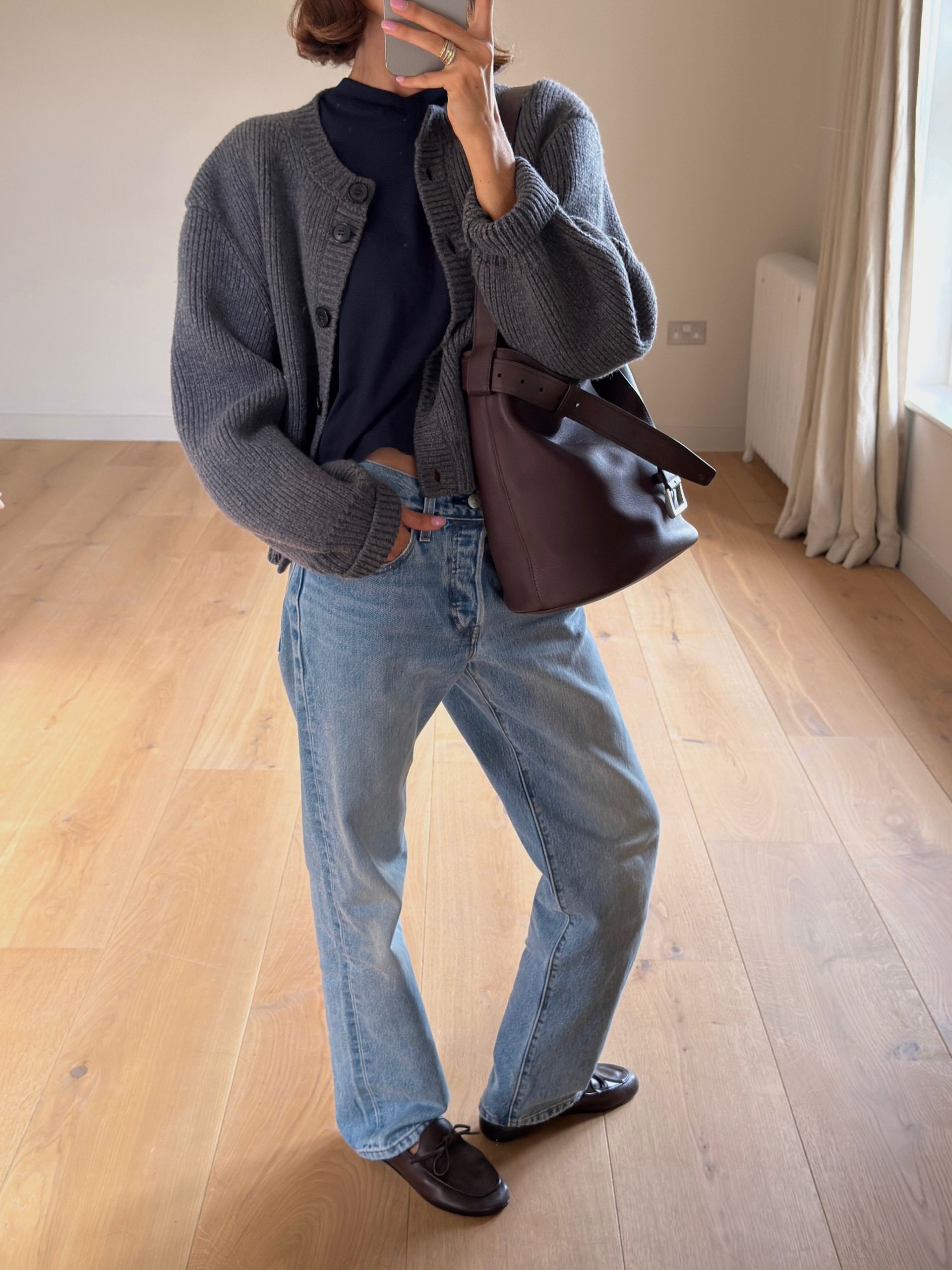 @smythsisters wearing a sweater and jeans