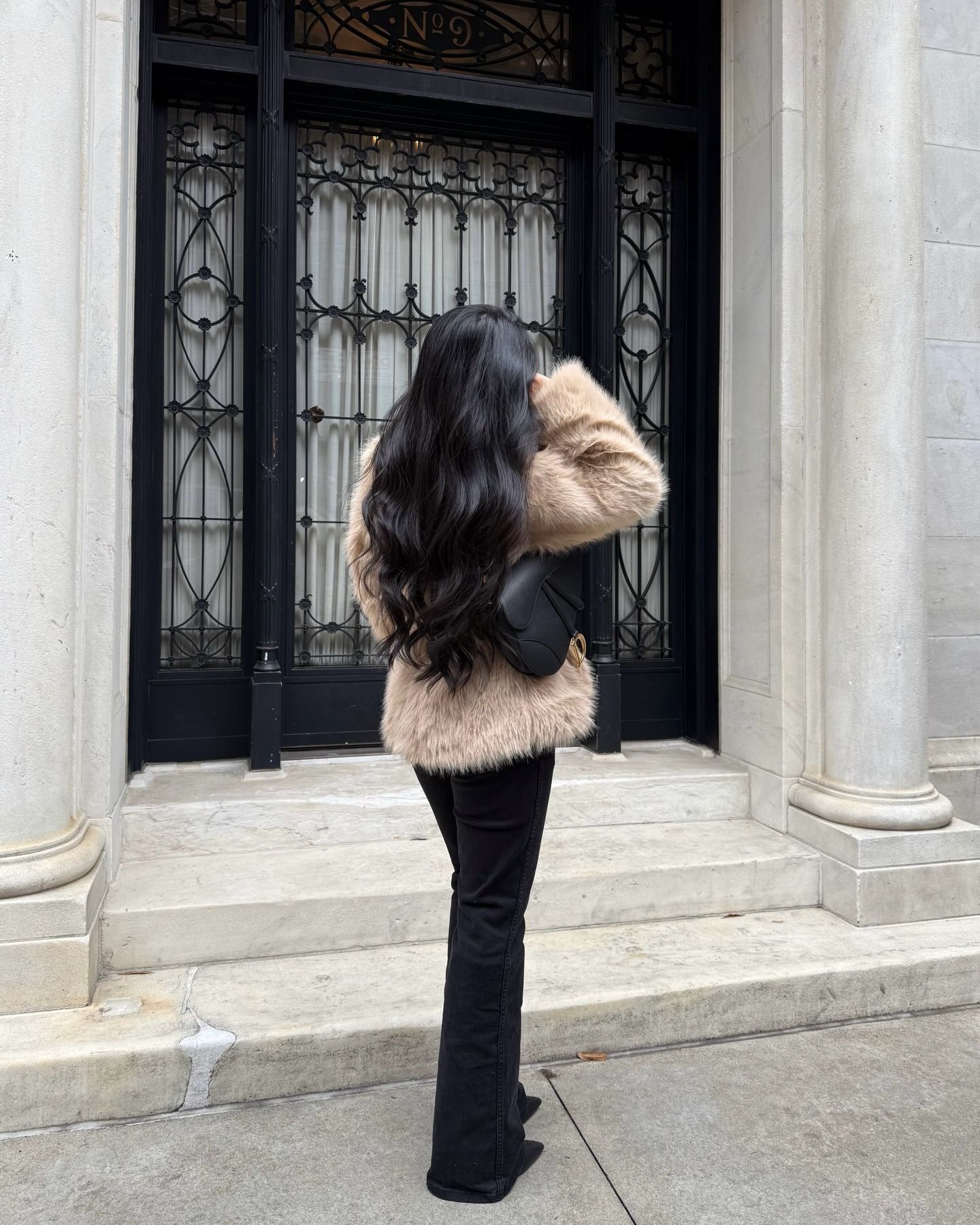Creator @leatngu wearing a winter coat and Dior handbag with long, glossy, wavy hair