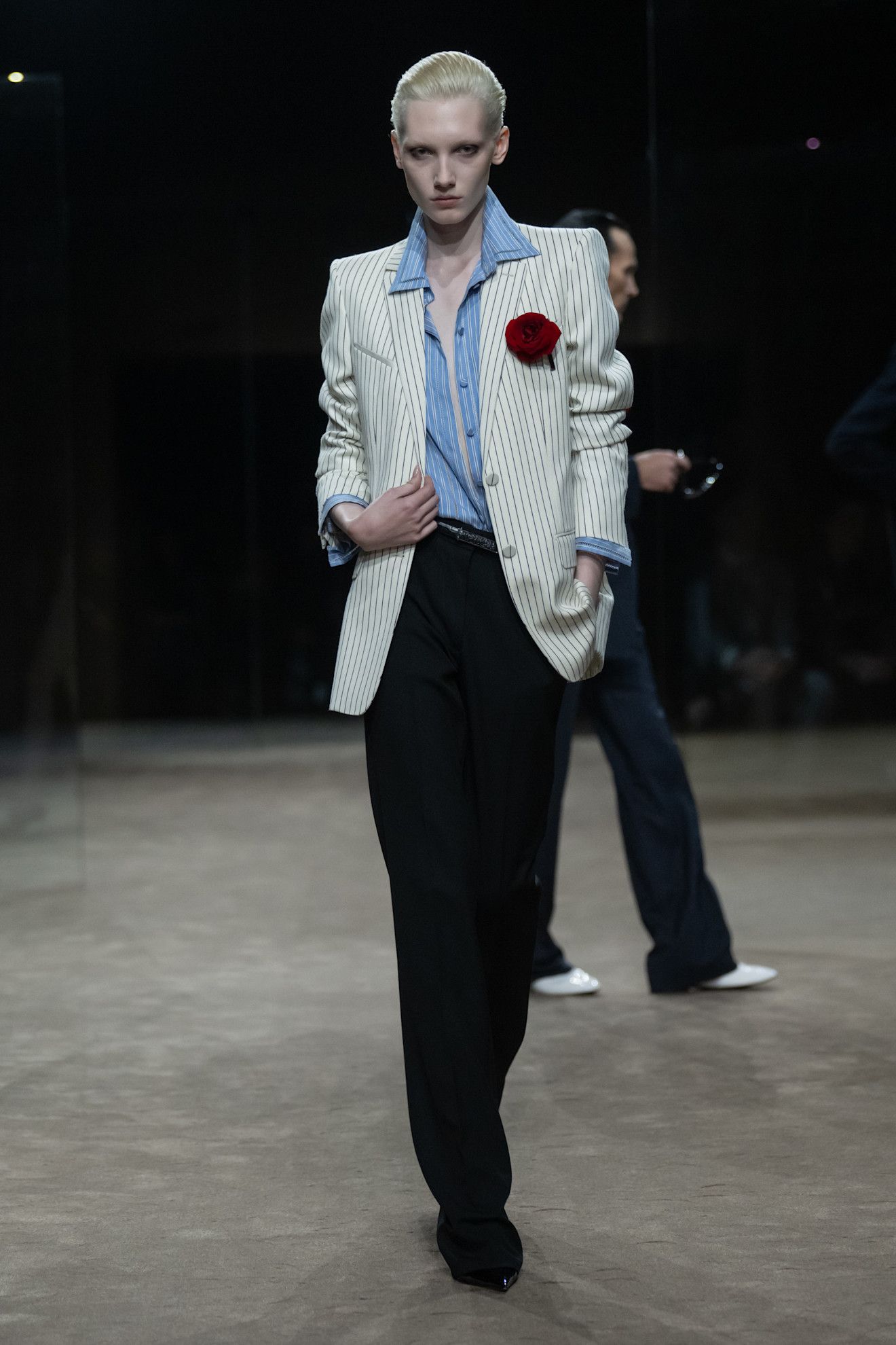 A model wears a rose pinned to the blazer at the tom ford show.