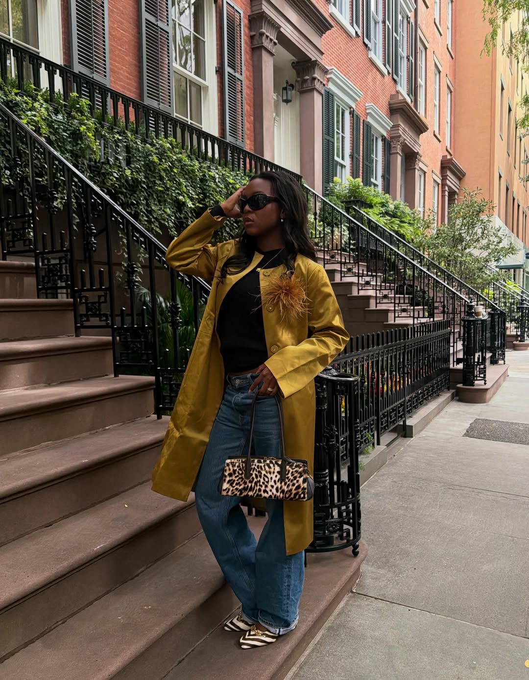@devapollon wears a gold coat with blue jeans and animal print accessories