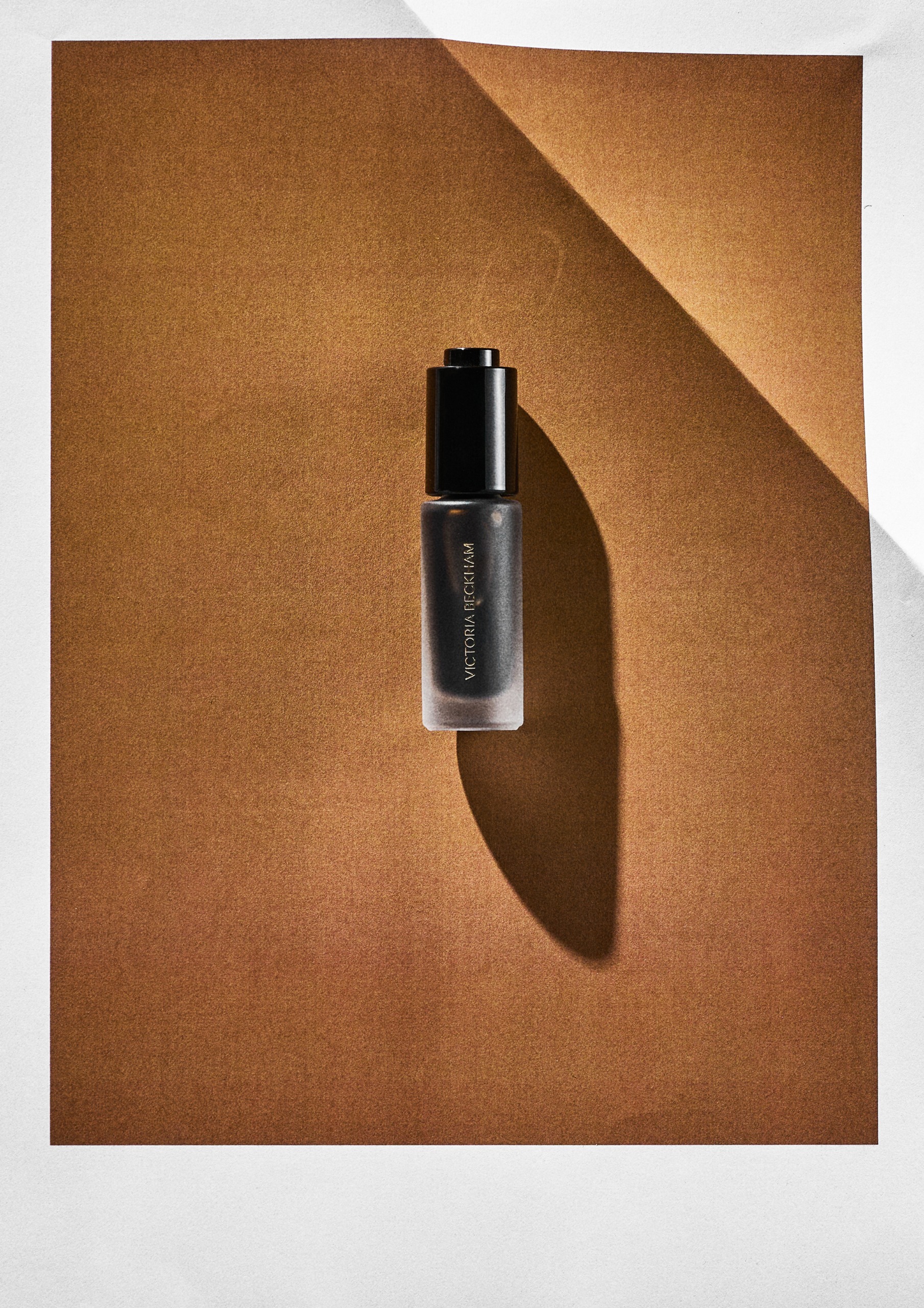 Victoria Beckham Beauty Colour Wash Bronze Water Tint on an orange background