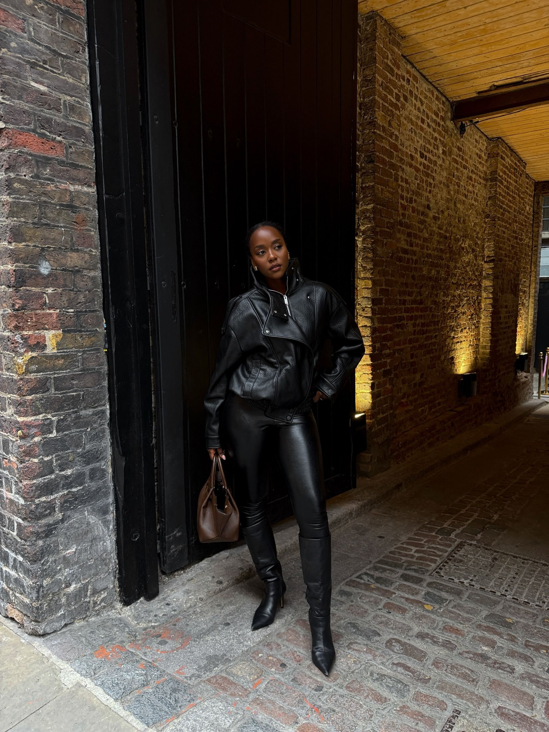 A woman wearing a fall leather-pant outfit in 2026.