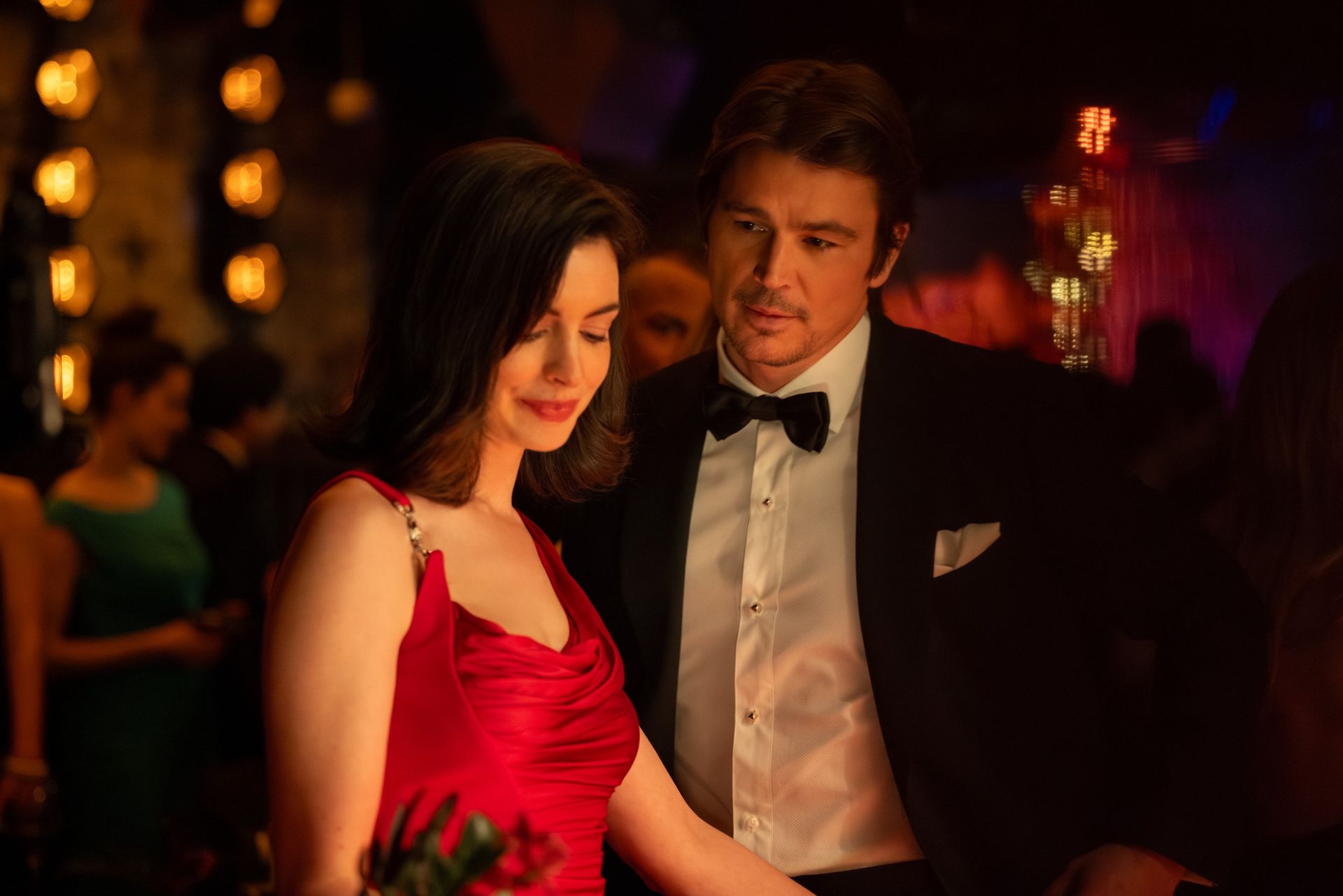 An image of Anne Hathaway wearing a red Versace dress in the 2026 movie Verity.