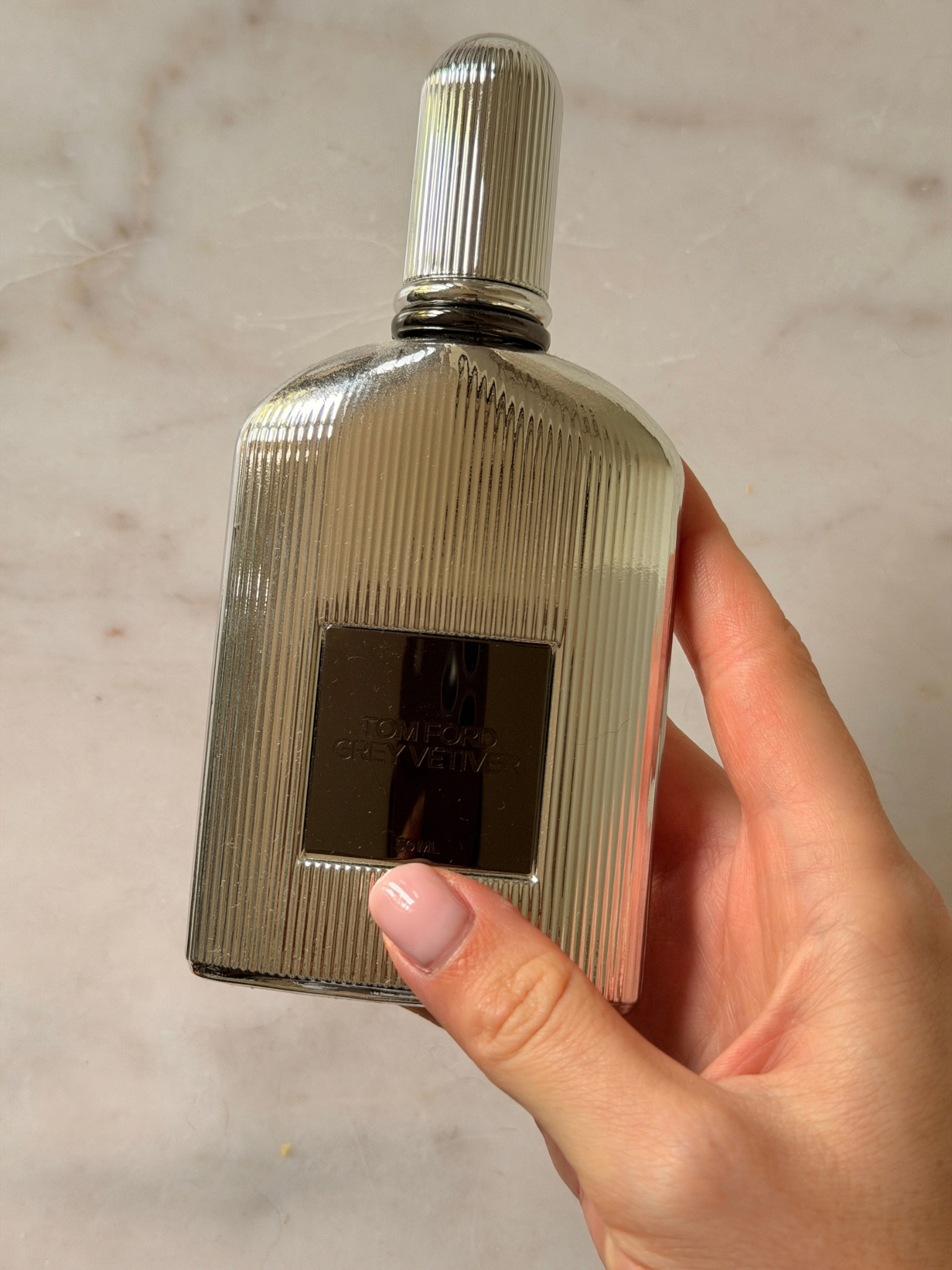Freelance beauty editor Grace Day holding a bottle of Tom Ford Grey Vetiver
