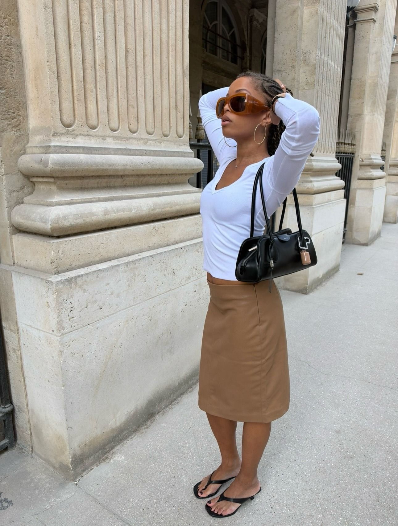 Woman in a white top and 90s midi skirt.