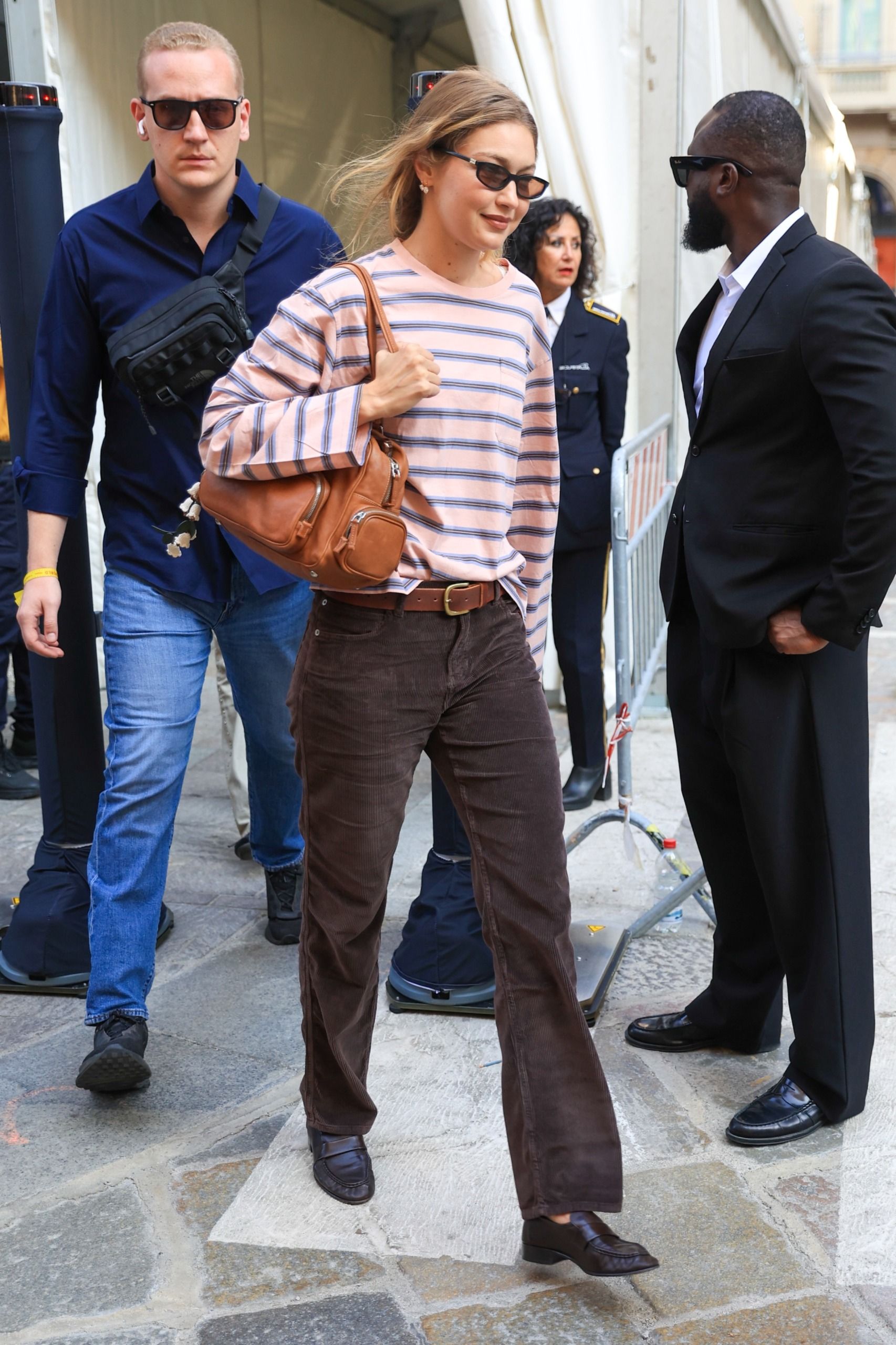 Gigi Hadid in a stripe shirt and brown corduroy pants