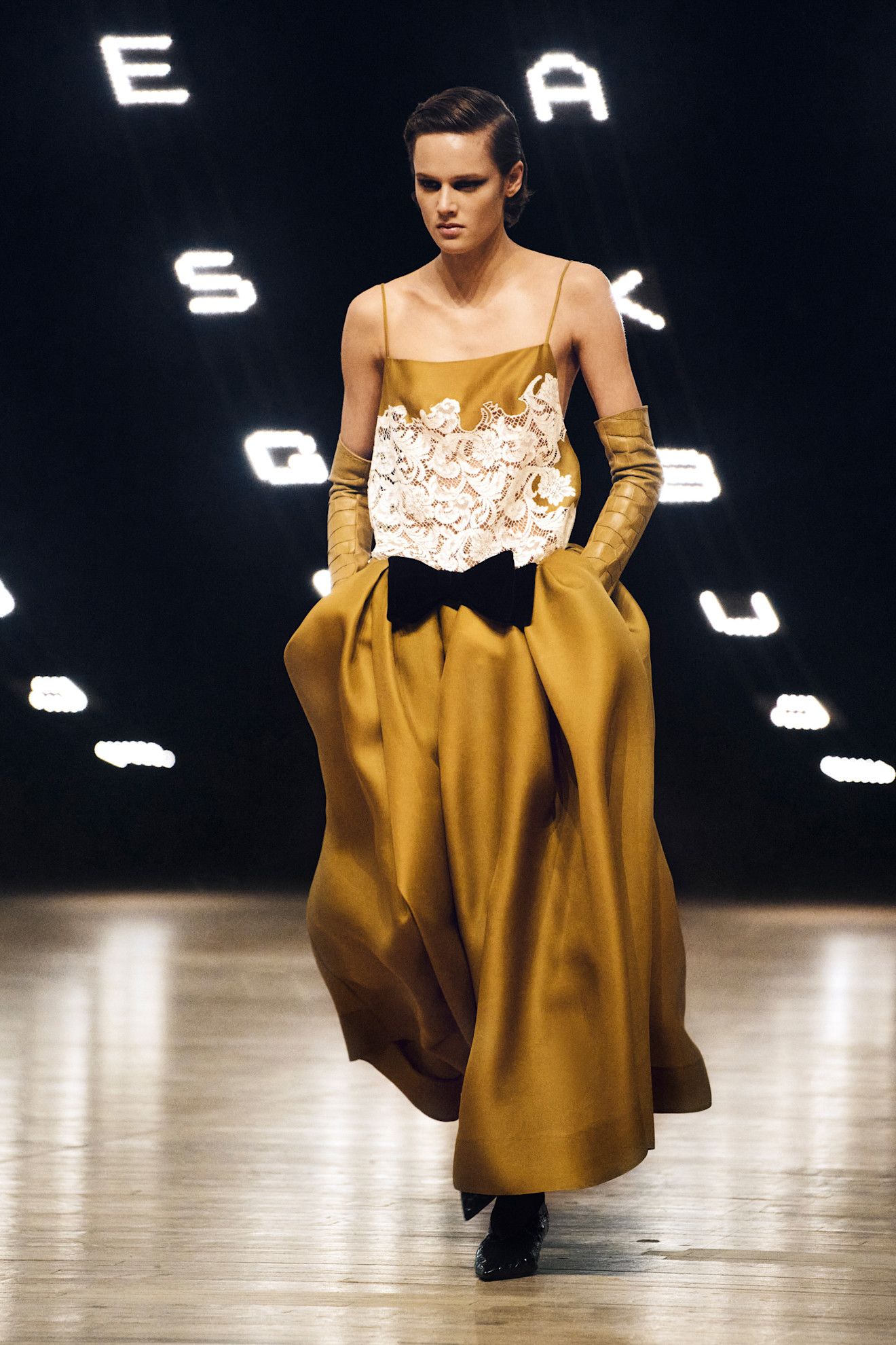 a Khaite runway look from the fall/winter 2026 collection that features the ochre color trend