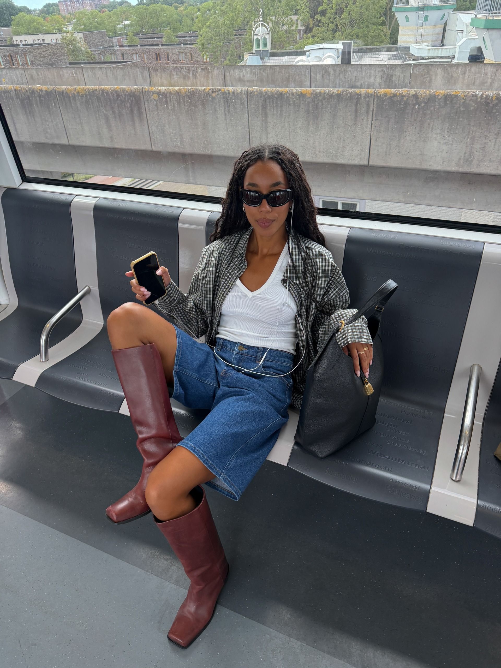 How to wear a plaid shirt 2026: casually cool.  Fashion person @amaka.hamelijnck shows how to wear a plaid shirt in 2026. She styled it with a white tank top, blue denim Bermuda shorts, and red boots