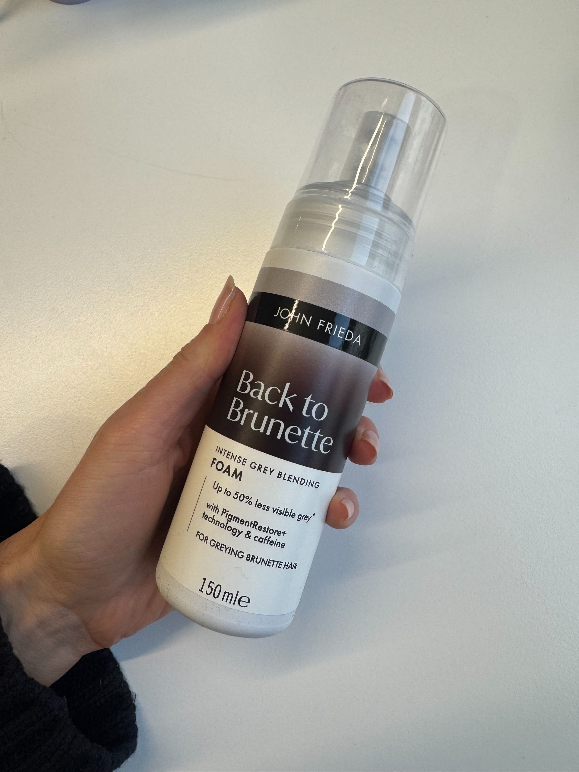 Eleanor holding a bottle of John Frieda Back to Brunette Foam