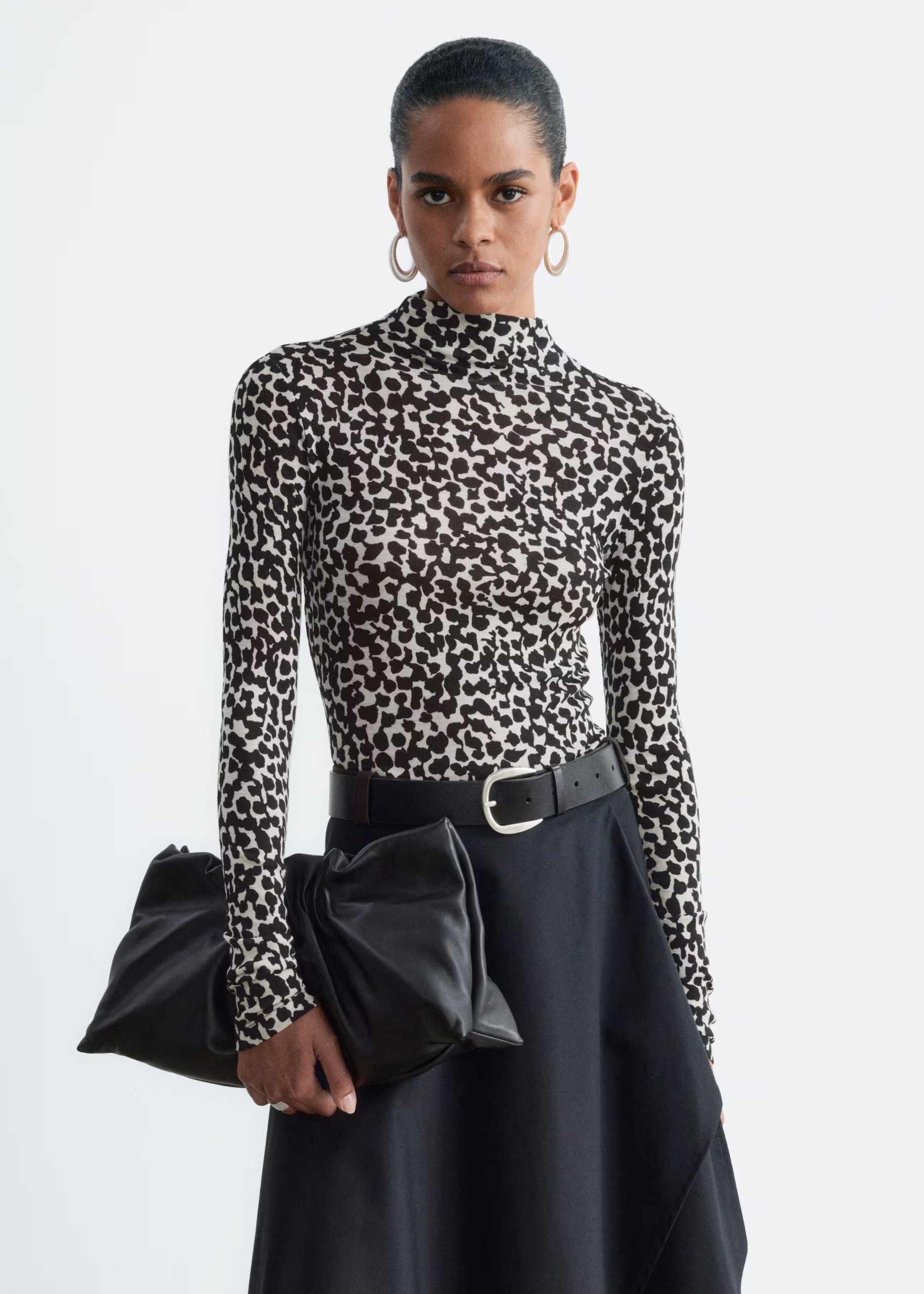 A model in a Dalmatian print long sleeve wool mock-neck top