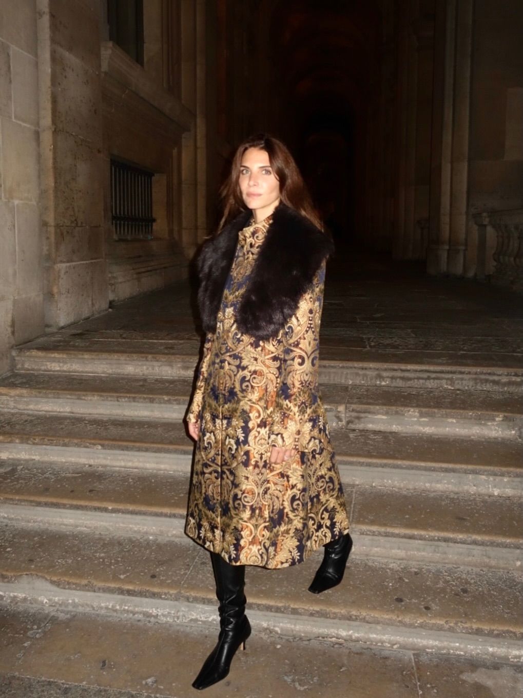 An image of @jen_wonders wearing slouchy boots with a fur-trimmed ornate coat.