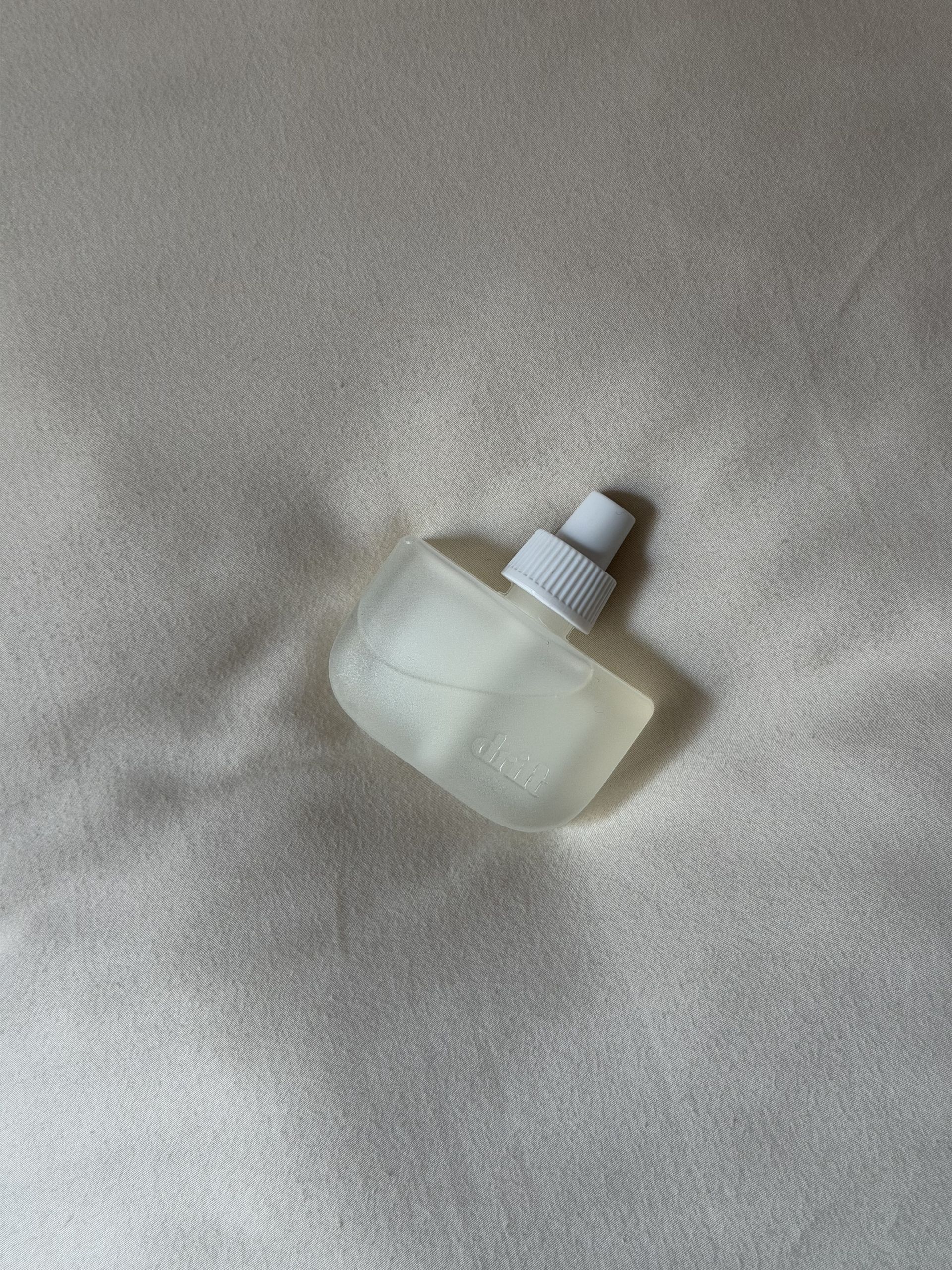 The Drift Home Scent Diffuser in Rest & Relax on a bed.