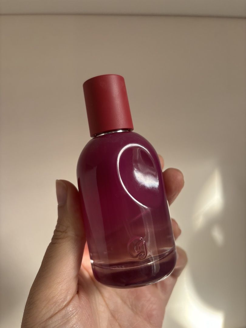 Mica Ricketts holding bottle of Glossier You R&ecirc;ve