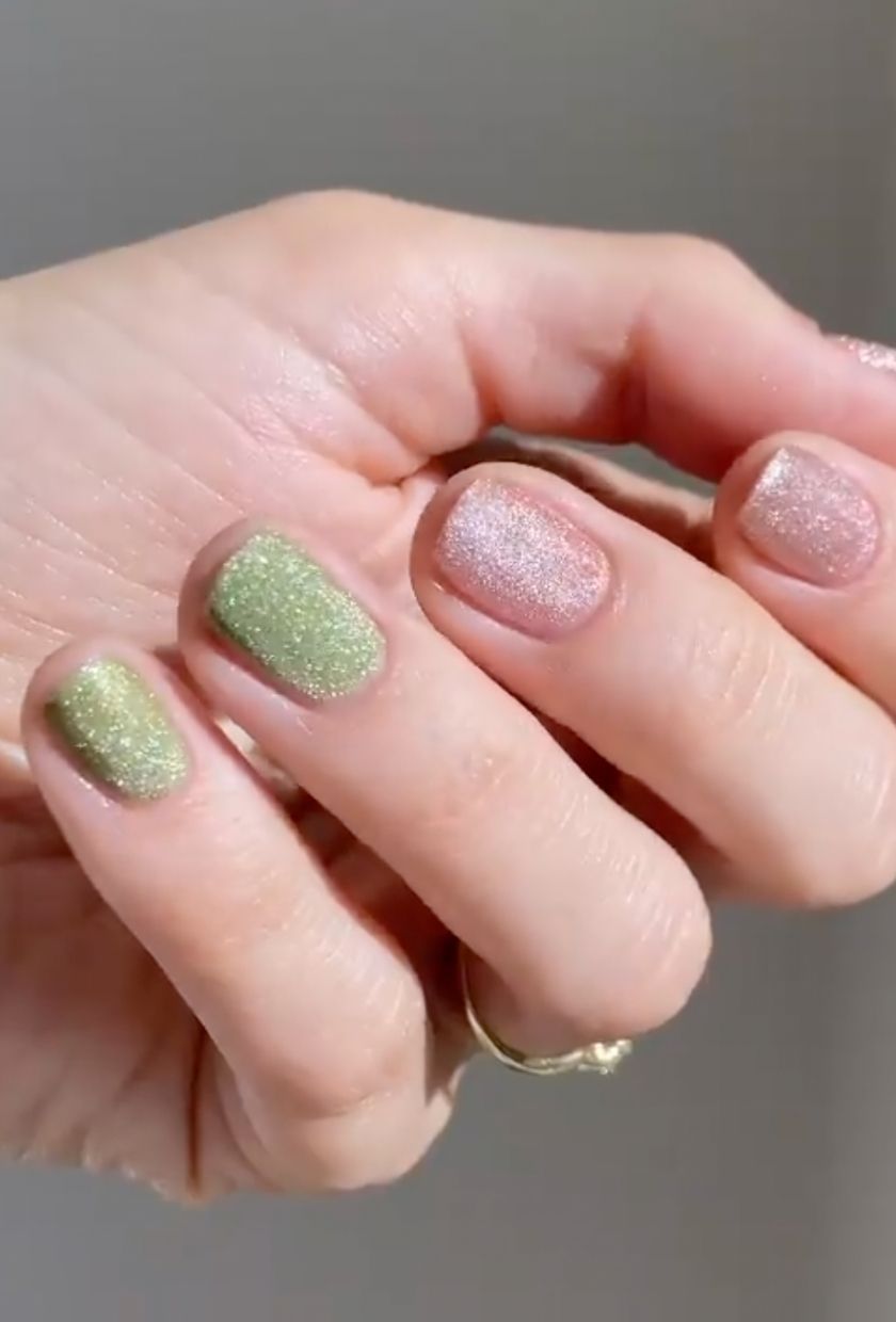 a close-up shot of green and baby pink velvet nails