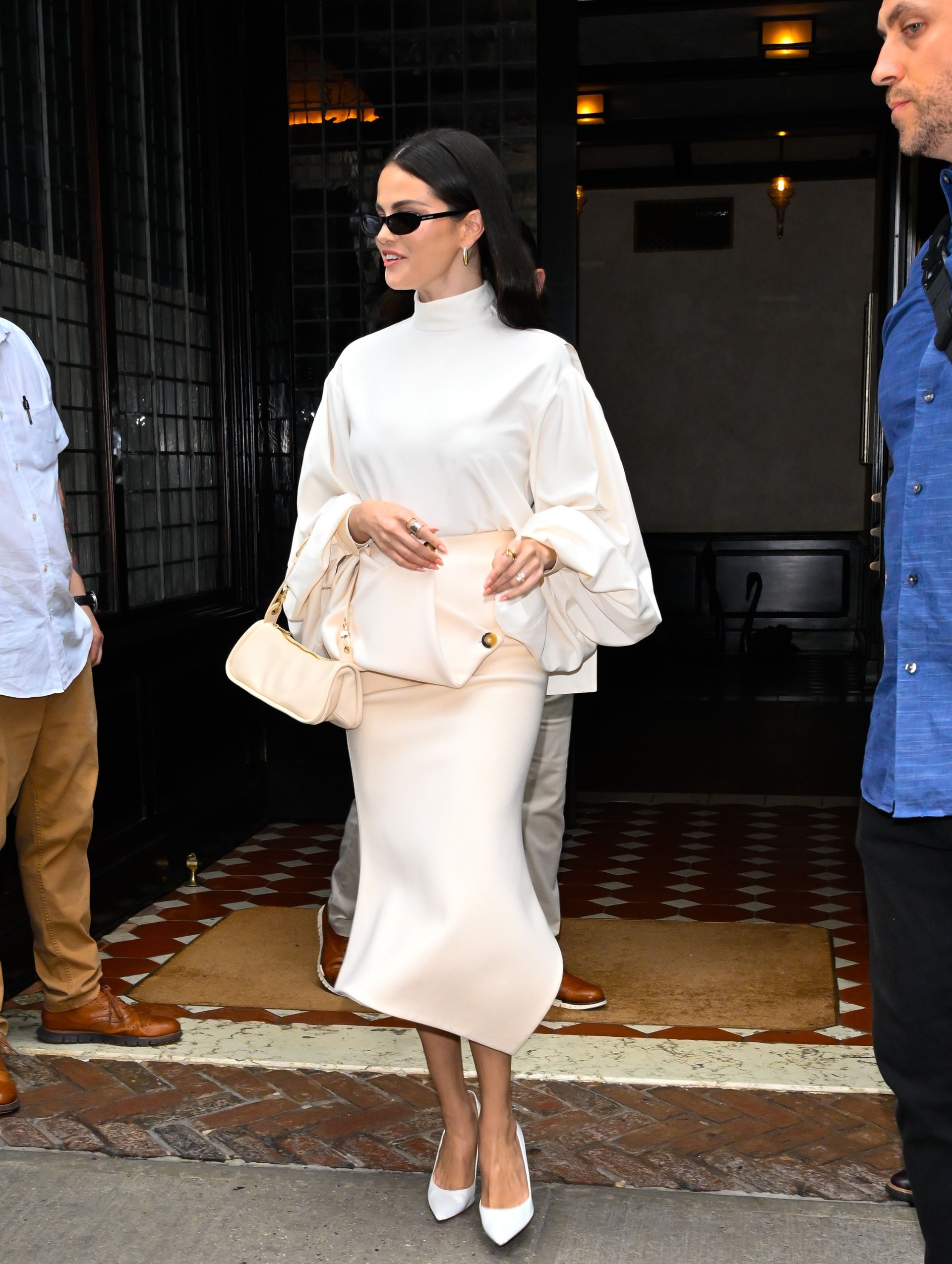 Selena Gomez wears a white turtleneck top with puff sleeves and a matching skirt.