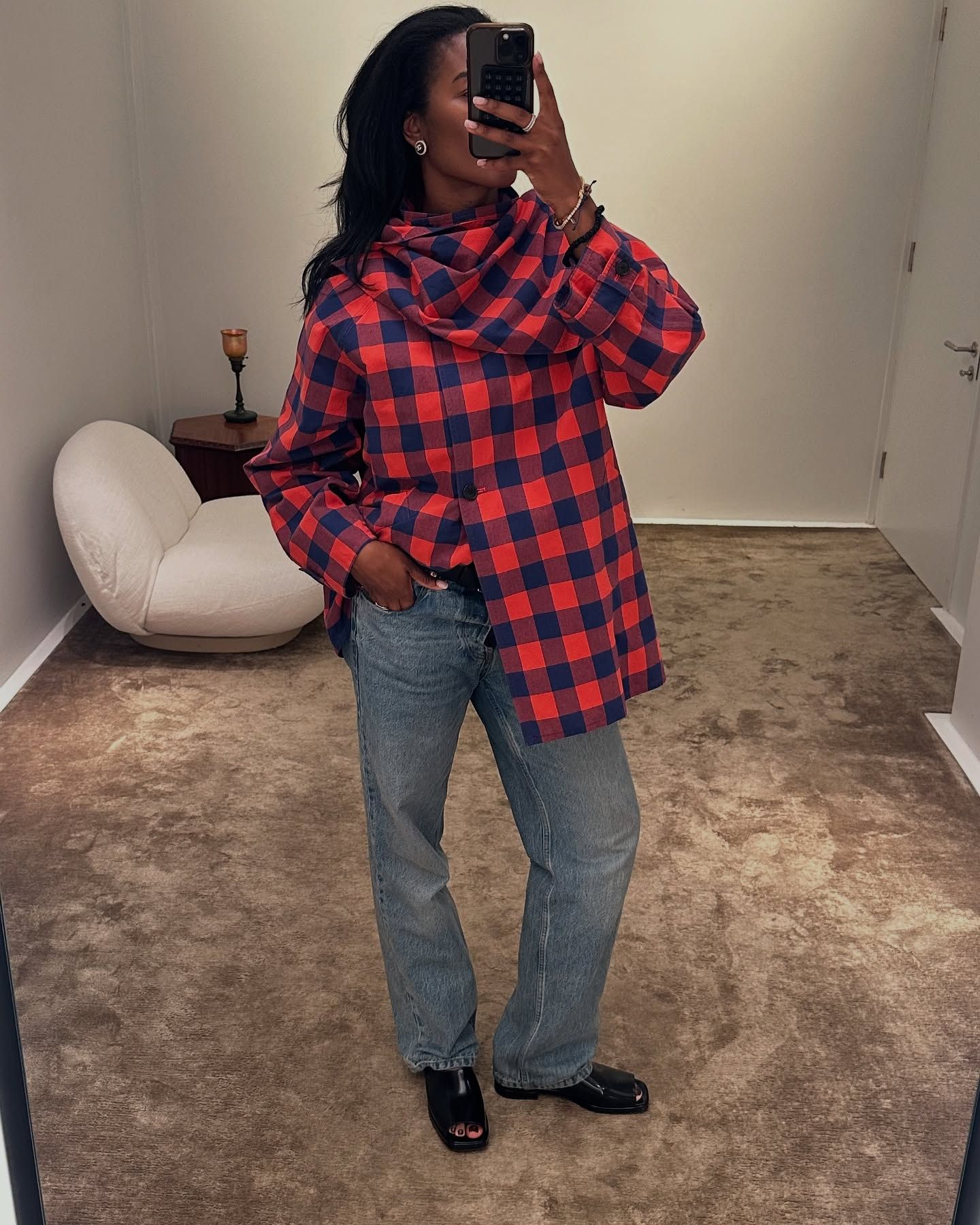 @nlmarilyn wears a red and navy checked scarf jacket from The Row with blue straight leg jeans and black peep toe sandals