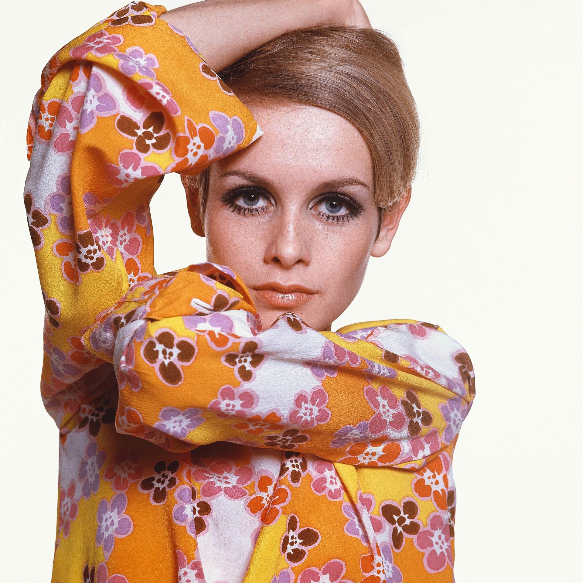 Twiggy in Max Factor make-up wearing flowered crepe dress by Michele Rosier.