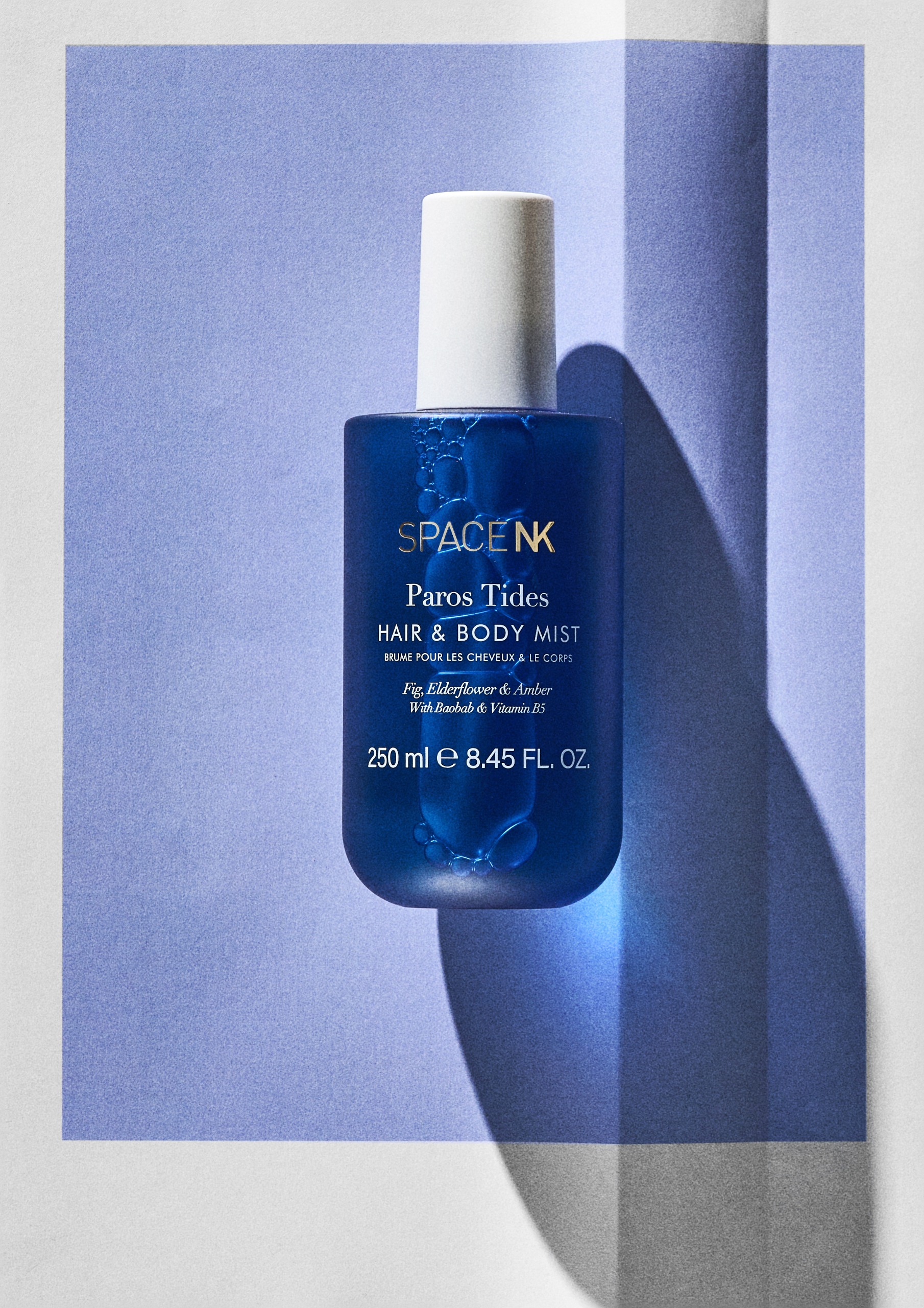 Space NK Paros Tides Hair & Body Mist on a blue background