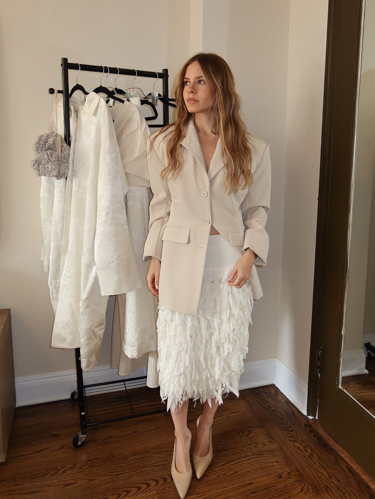 nikki wears a fringe skirt and a blazer.