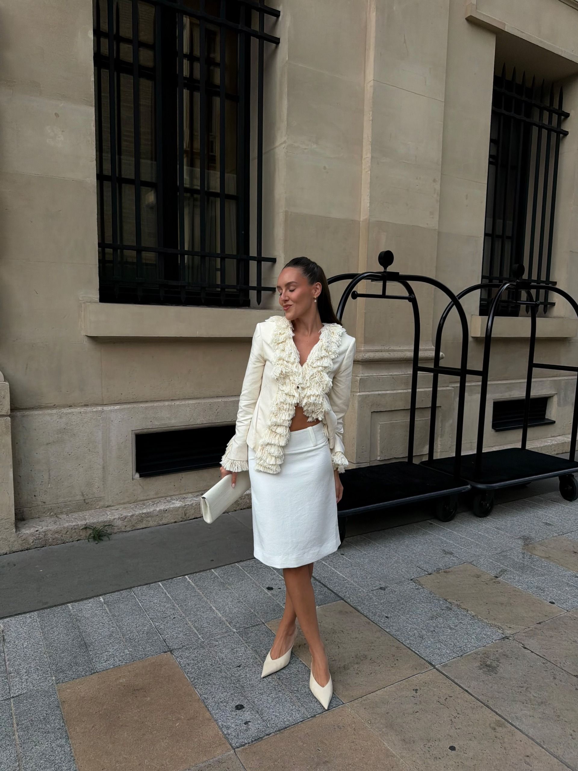 An image of @emmaleger wearing a tasselled jacket with a pencil skirt.