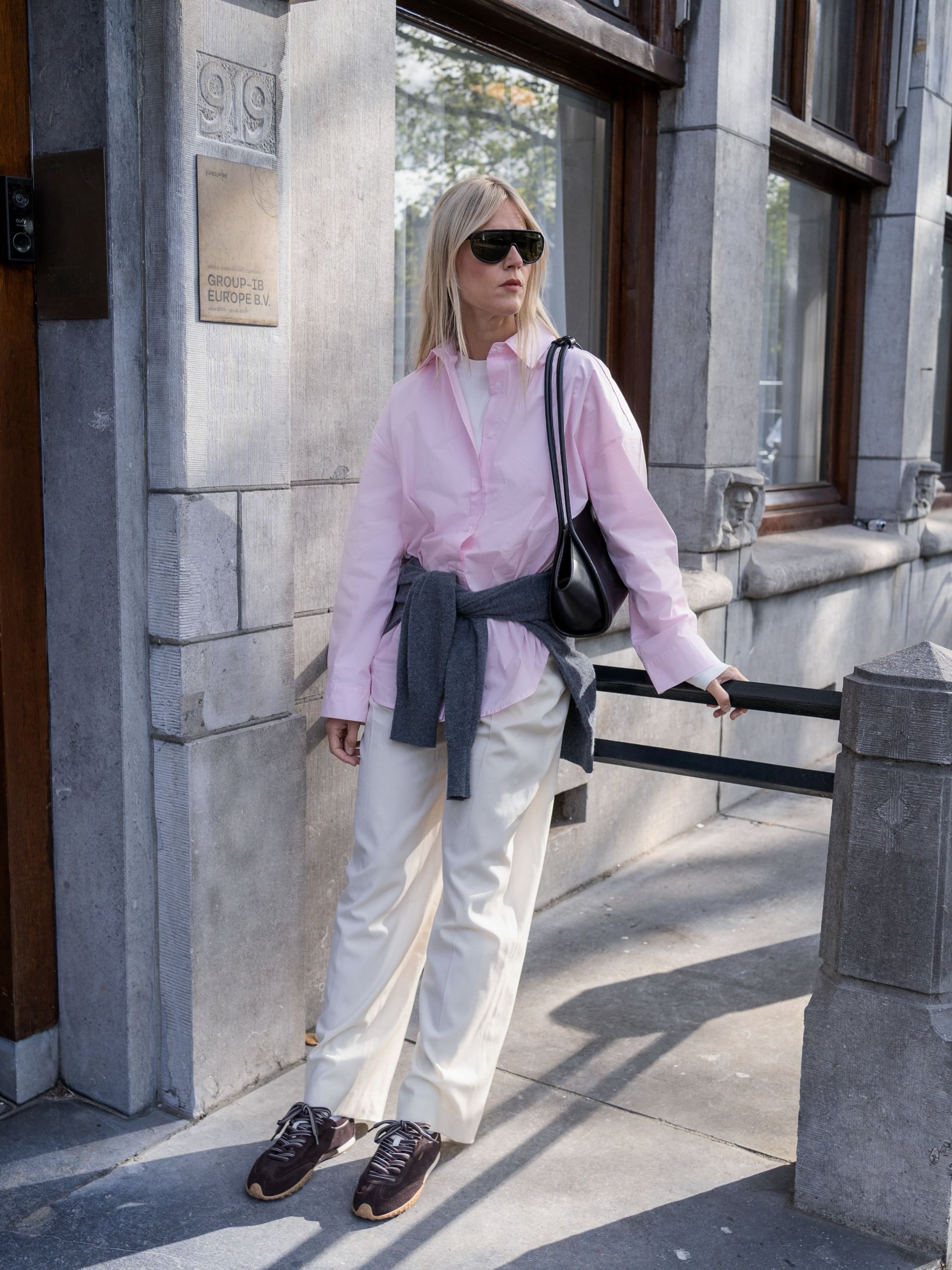 Influencer wearing a pink button-down, khaki pants, and brown sneakers