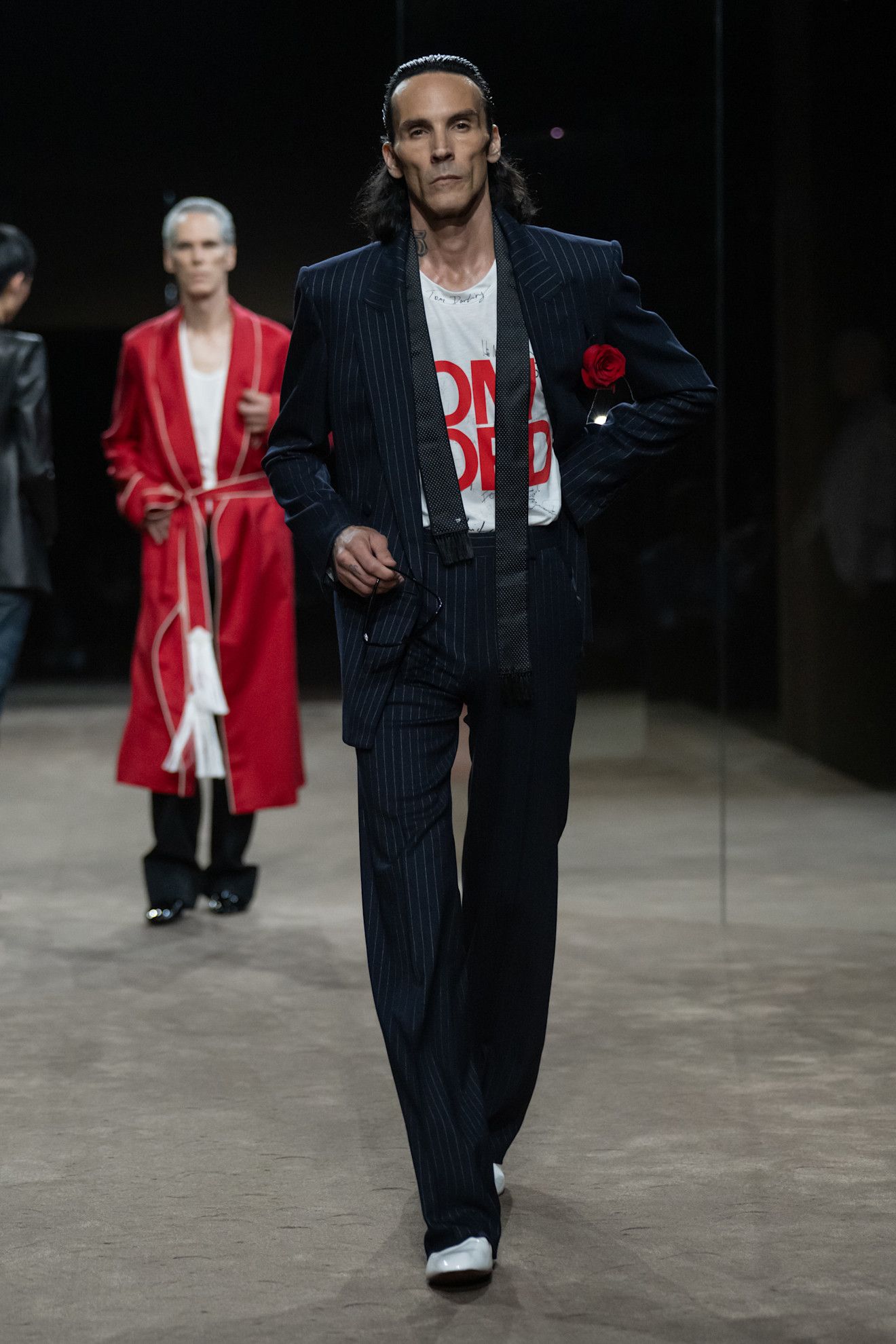 A model wears a rose pinned to the blazer at the tom ford show.