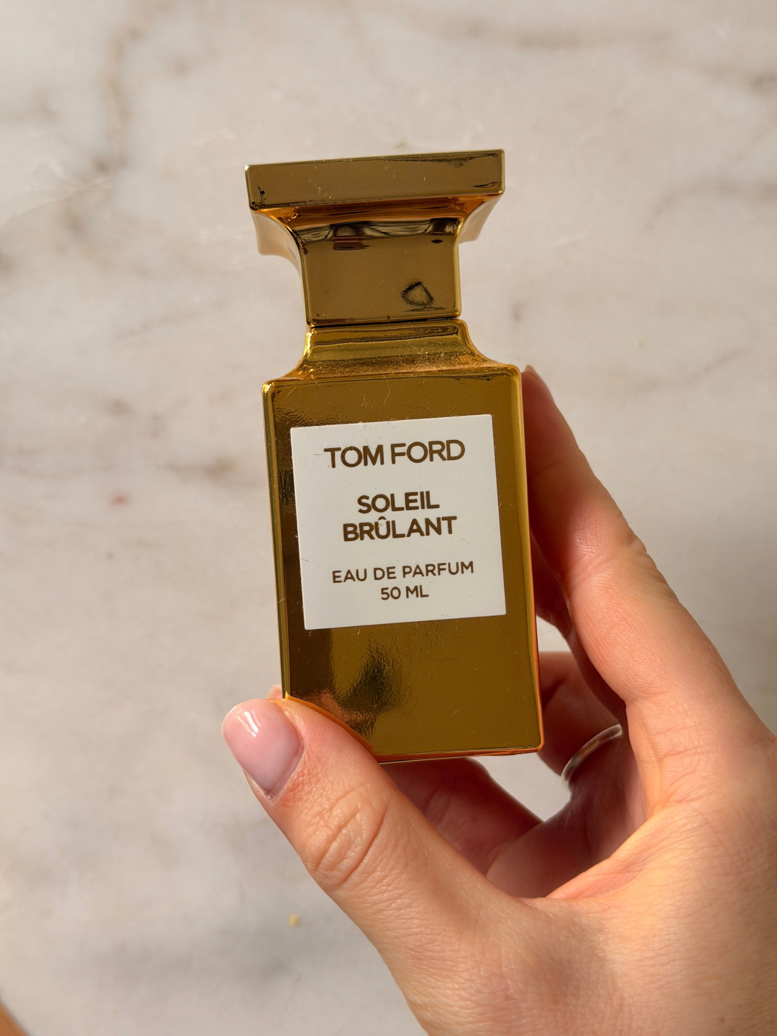 Freelance beauty editor Grace Day holding a bottle of Tom Ford Soleil Brulant