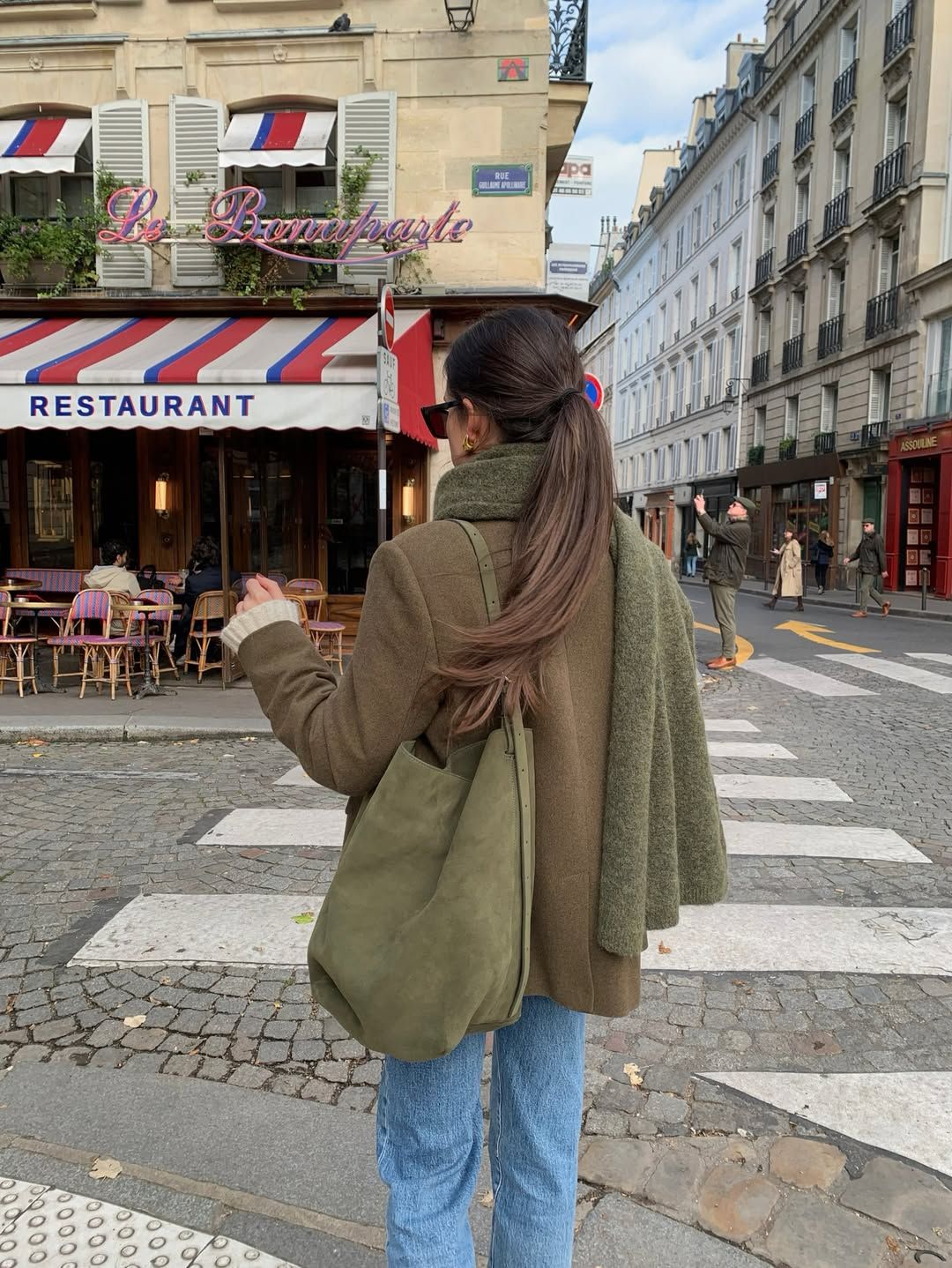 @leasy_inparis wears an olive green jacket, scarf and bag with blue jeans