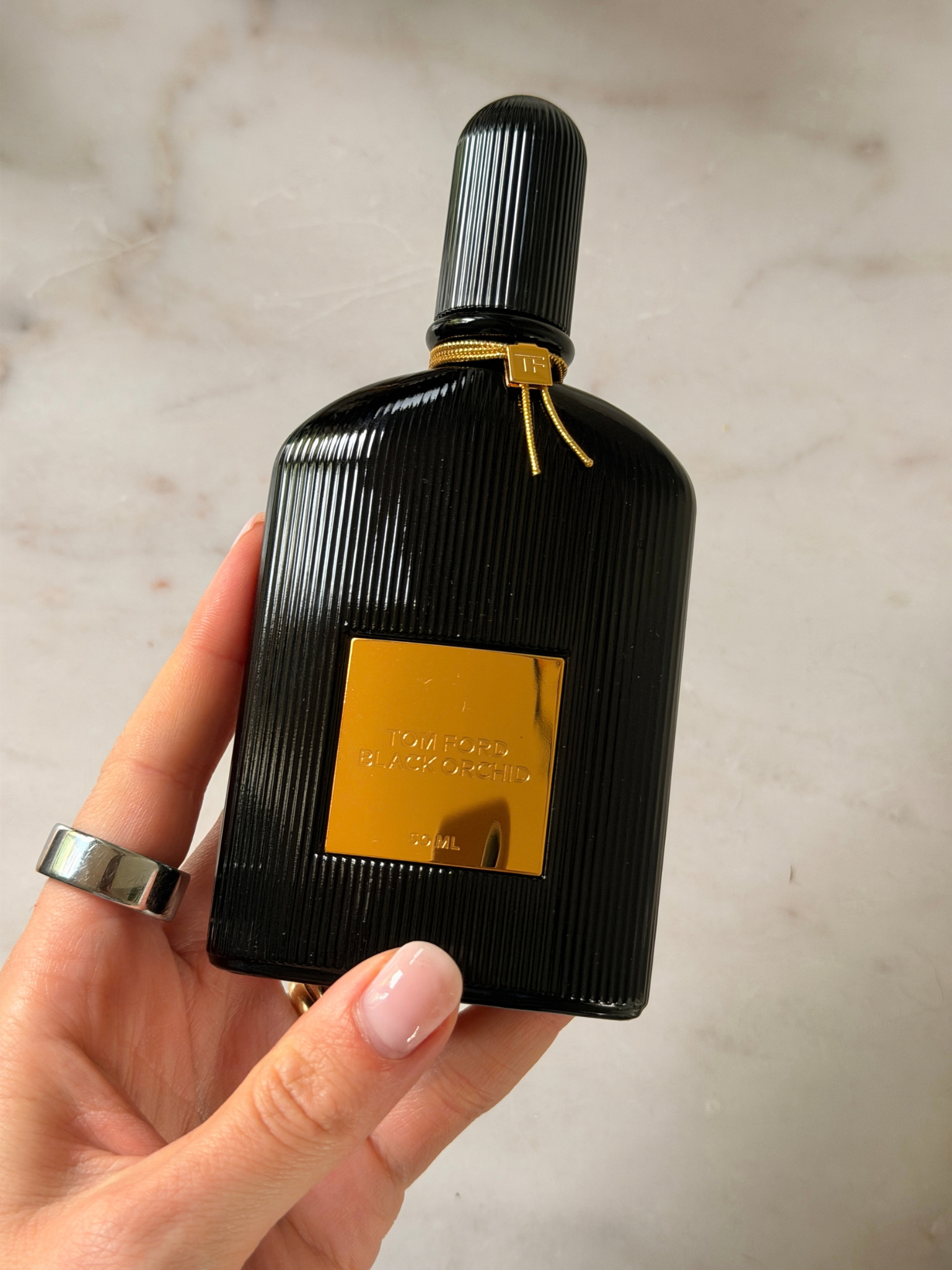 Freelance beauty editor Grace Day holding a bottle of Tom Ford Black Orchid