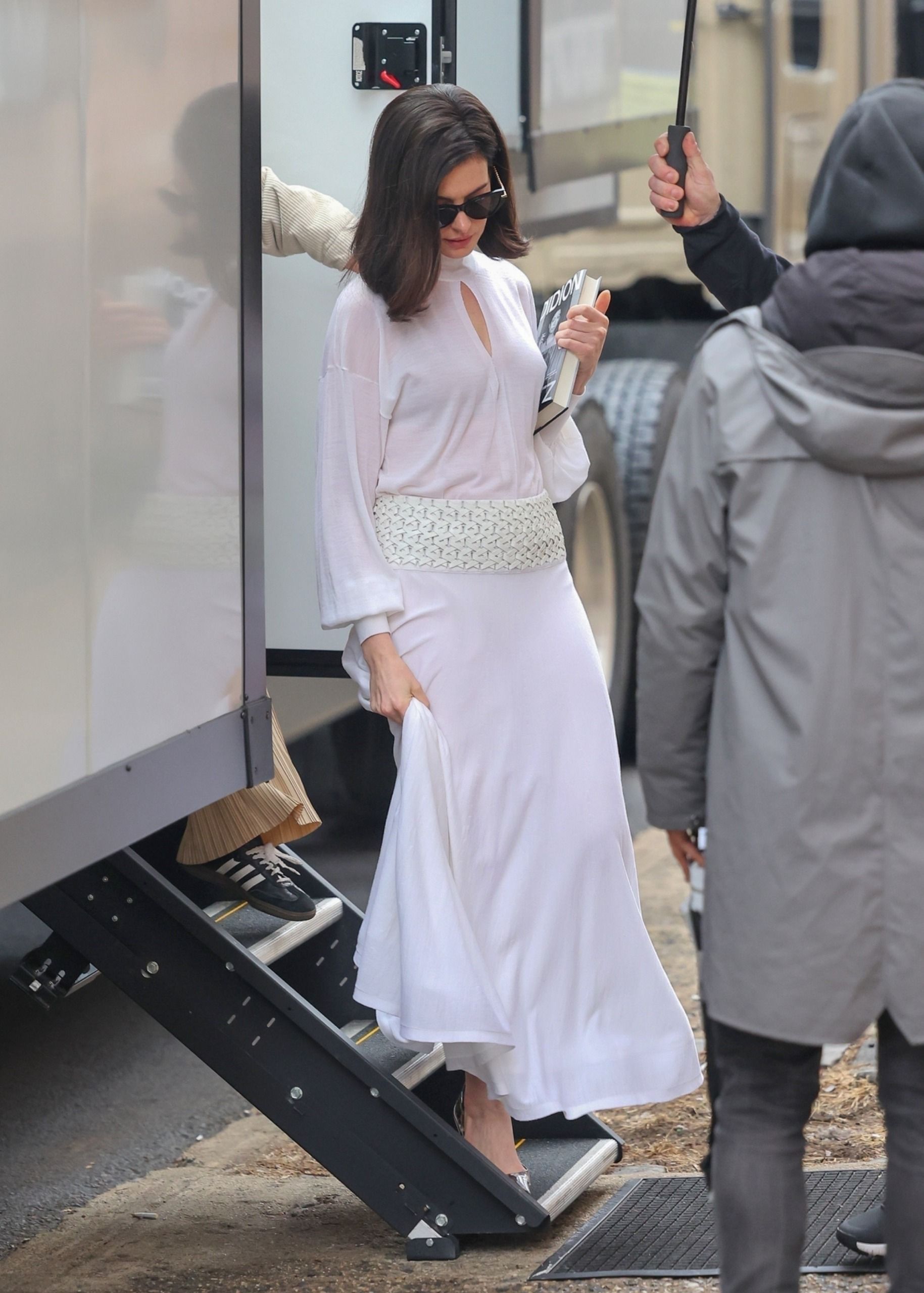 An image of Anne Hathaway wearing an Alaia white blouse and skirt whilst on set of the 2026 film Verity.